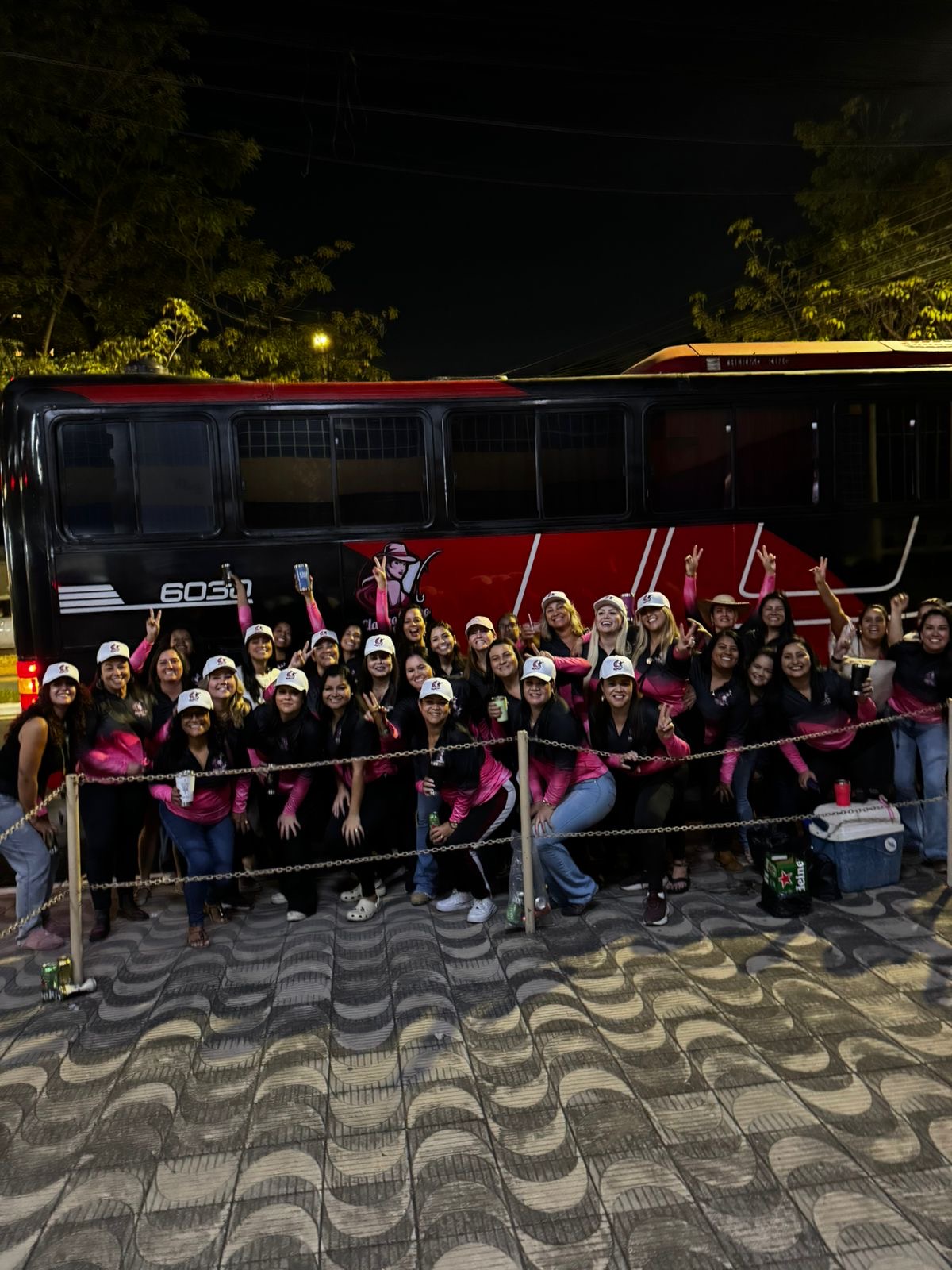 Grupo de mulheres na frente do ônibus da viagem